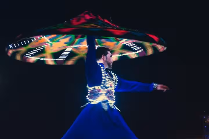 Experience the vibrant Tanoura dance performance under the starry desert sky on the Abu Dhabi Desert Safari.