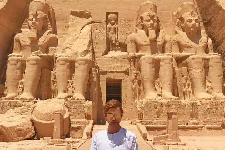 Traveler at Abu Simbel Great Temple statues on day tour from Aswan, Egypt Nubian monuments