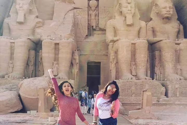 Friends posing at Abu Simbel Great Temple entrance on full-day guided tour from Aswan, Egypt day trip