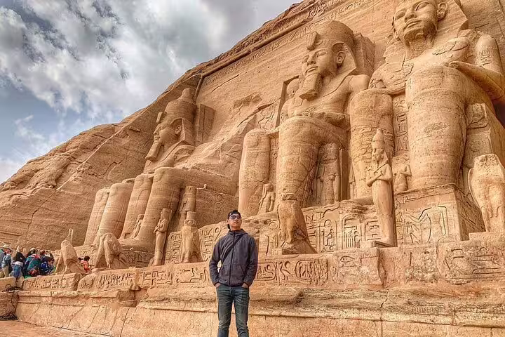 Wide view of Abu Simbel Great Temple statues with tourists, full-day guided tour from Aswan in Egypt