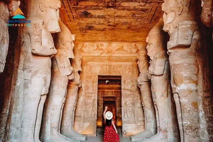 Inside Abu Simbel temple hall with colossal statues on a full-day guided tour from Aswan, Egypt day trip