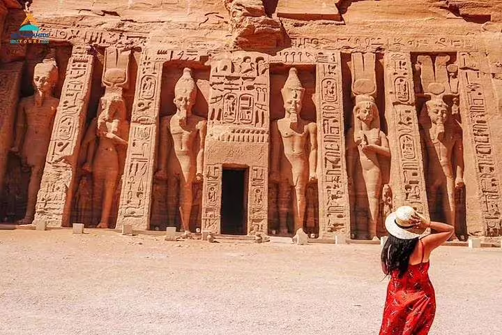 Traveler at Abu Simbel temple facade on full-day guided tour from Aswan, exploring ancient Nubian carvings