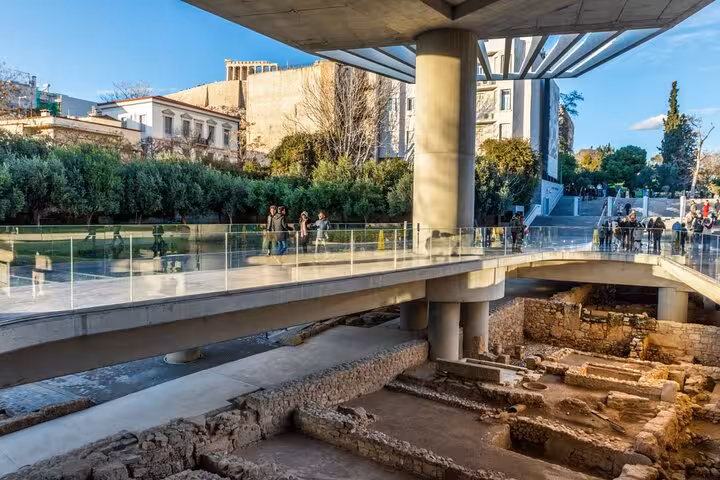 Visitors walk above ancient ruins at the Acropolis Museum, a highlight of the Athens full-day private tour.