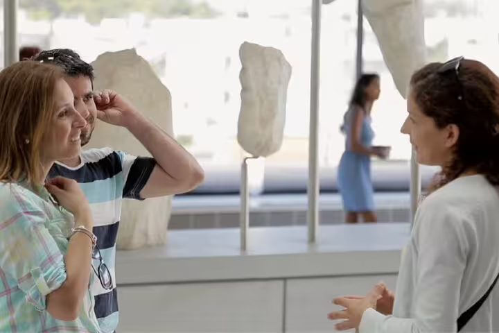 Guide briefing guests beside ancient marble fragments at Acropolis Museum on Friday night tour in Athens