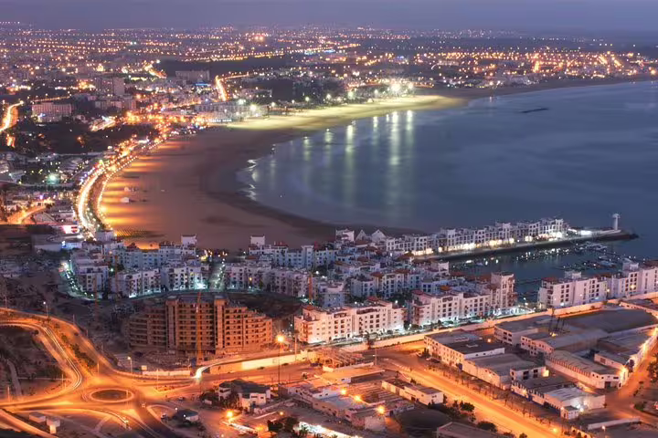 Night view of Agadir bay and beachfront lights, coastal stop on Morocco Anti-Atlas & Sahara 8-day tour