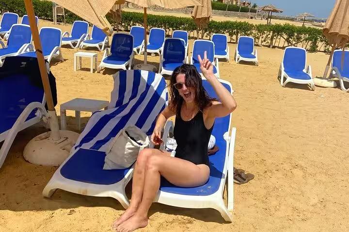 Traveler relaxing on beach lounger under umbrellas in Ain El Sokhna on a Cairo day tour, Red Sea resort