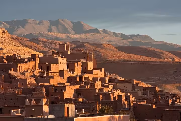 Majestic Ait Benhaddou with Atlas Mountains backdrop on the Fes to Marrakech luxury desert tour.