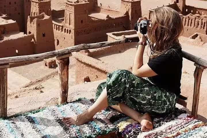 Traveler photographing Ait Benhaddou kasbah viewpoint on Morocco 9-day tour from Tangier to Marrakech