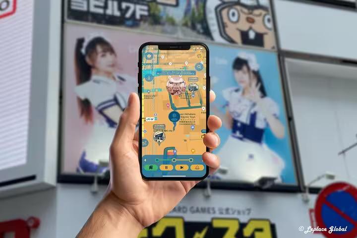 Akihabara anime walking tour mobile app navigation map displayed on phone with idol posters in background Japan