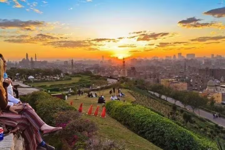 Sunset panorama from Al Azhar Park overlooking Islamic Cairo skyline, perfect stop on Al-Mu'izz tour with dinner