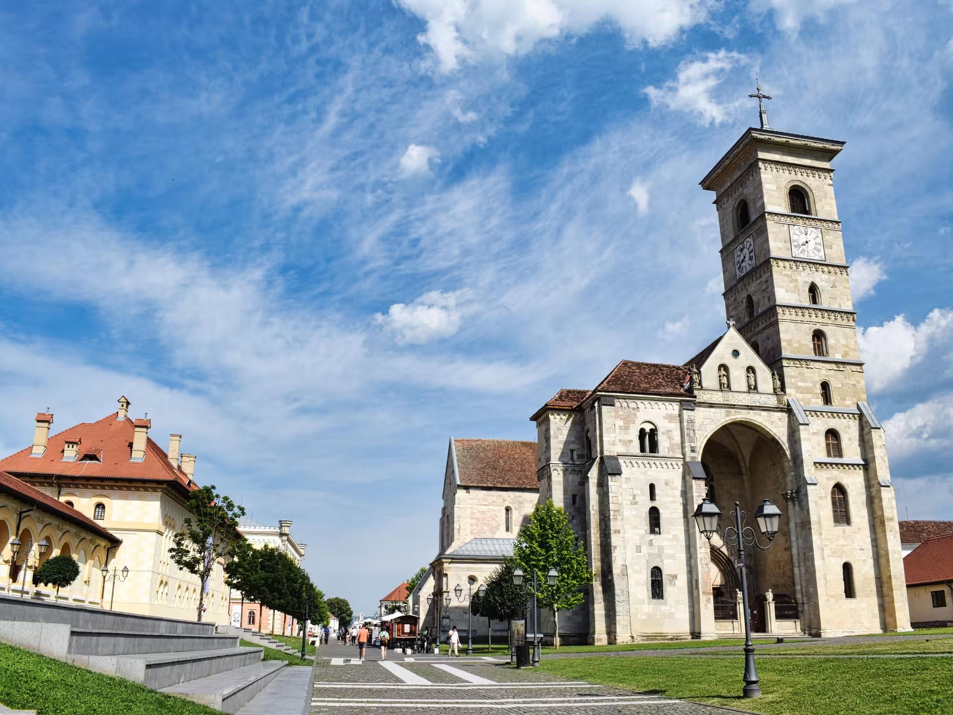 Historic Alba Iulia Cathedral with clock tower on a sunny day during a full-day tour of Transylvania Romania