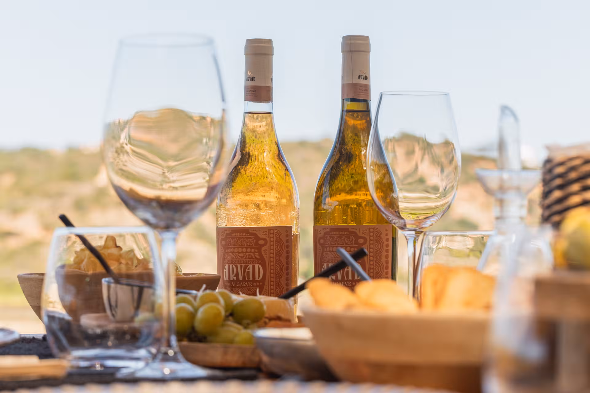 Tasting table with Algarve white wine bottles, empty glasses, olives and snacks on the Algarve Cans & Bottles tour