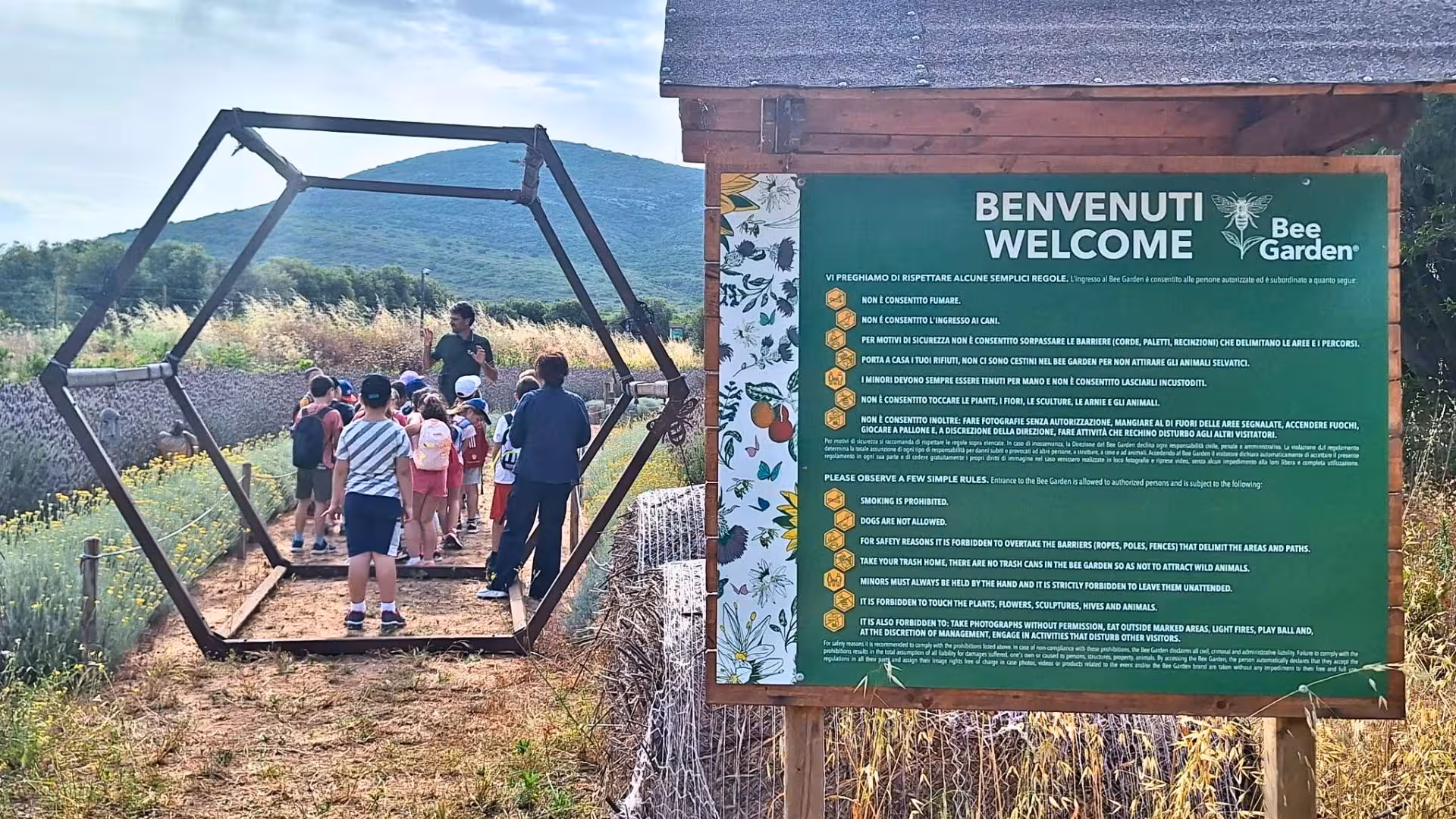 Children explore the Alghero bee garden in Guardia Grande with a guide, learning about bees and nature conservation.