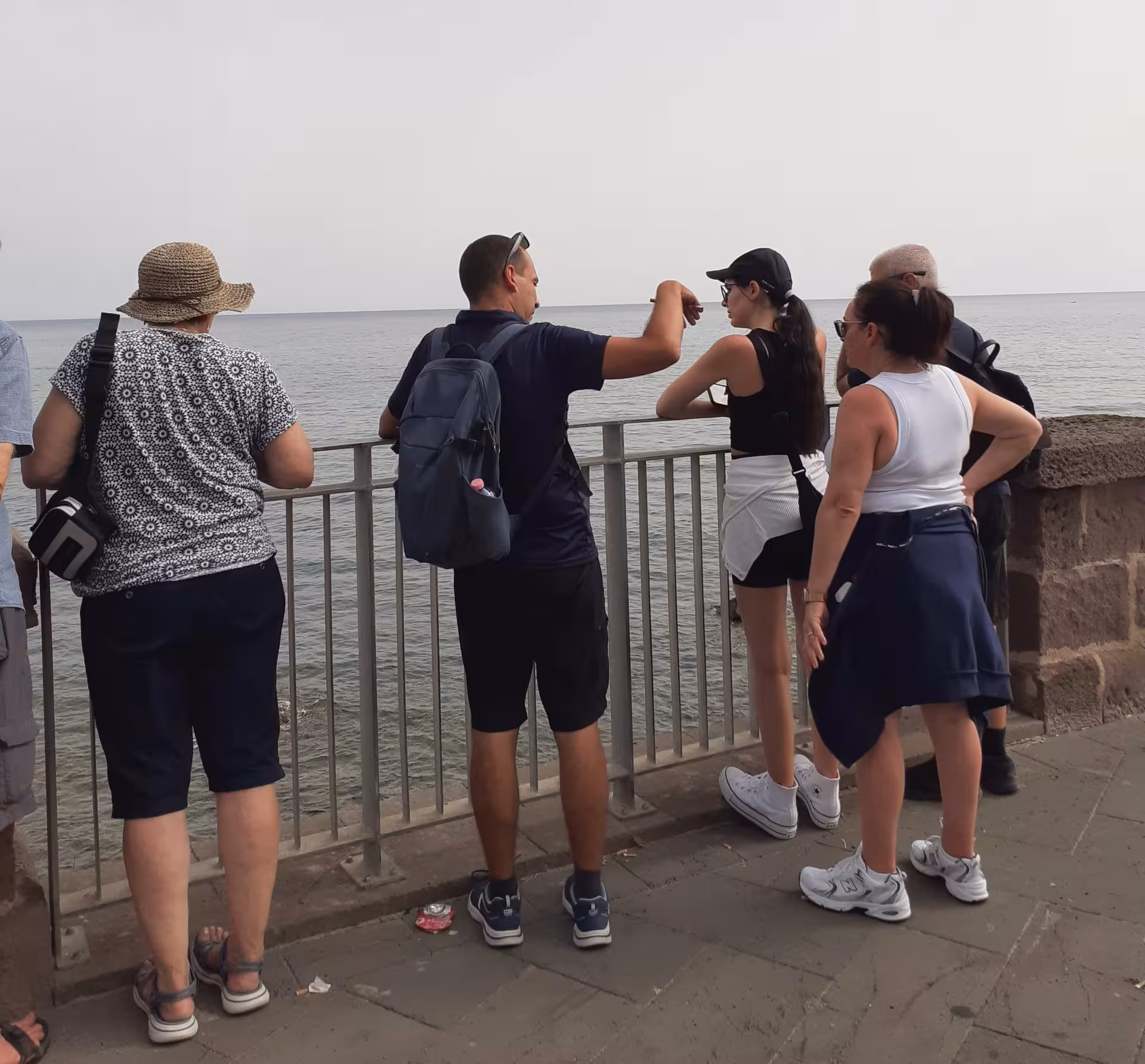 Tourists enjoy scenic views of the Alghero coast during a guided historic center tour.