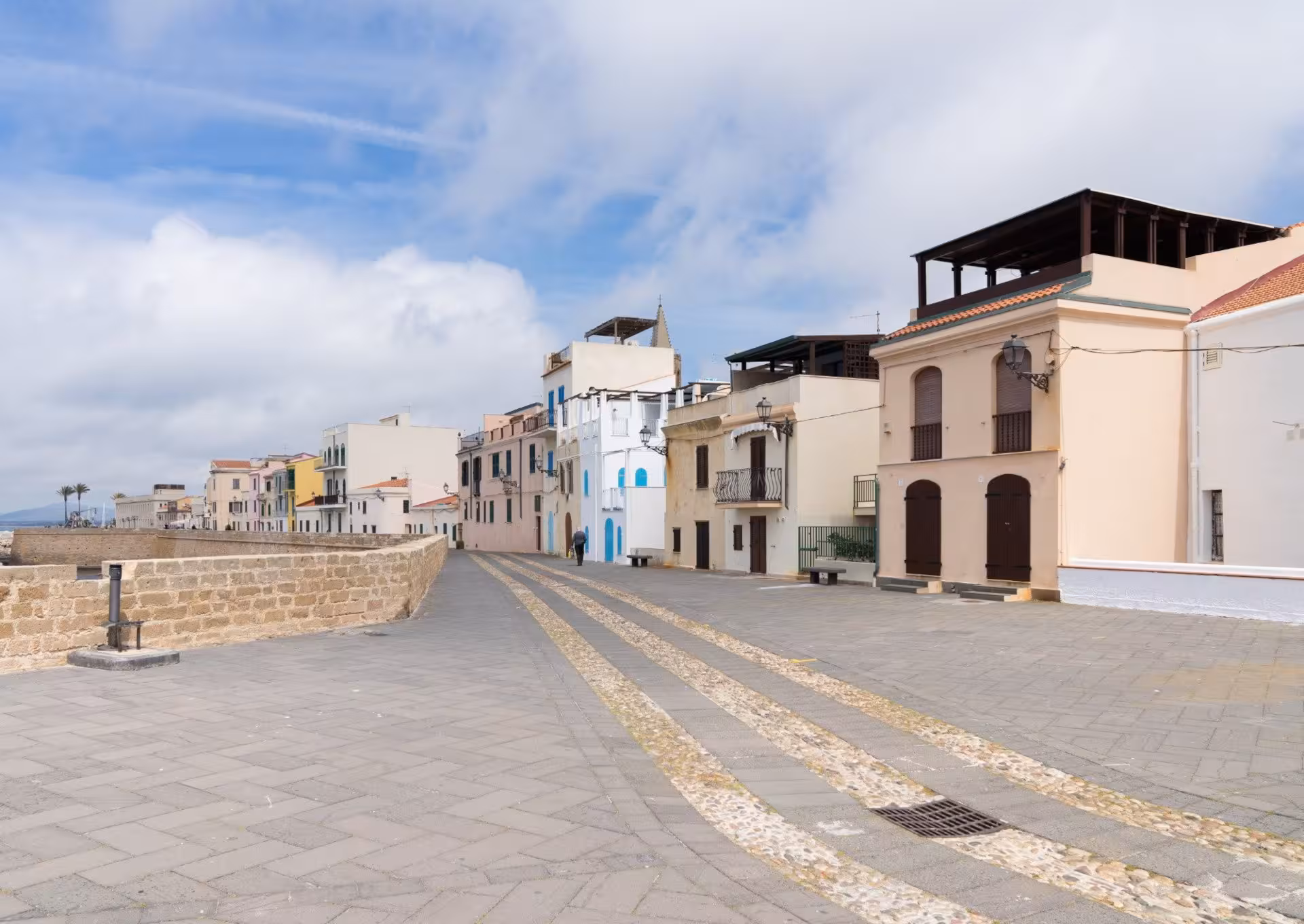 Scenic view of Alghero's colorful historic centre along the cobblestone street, perfect for walking tours.
