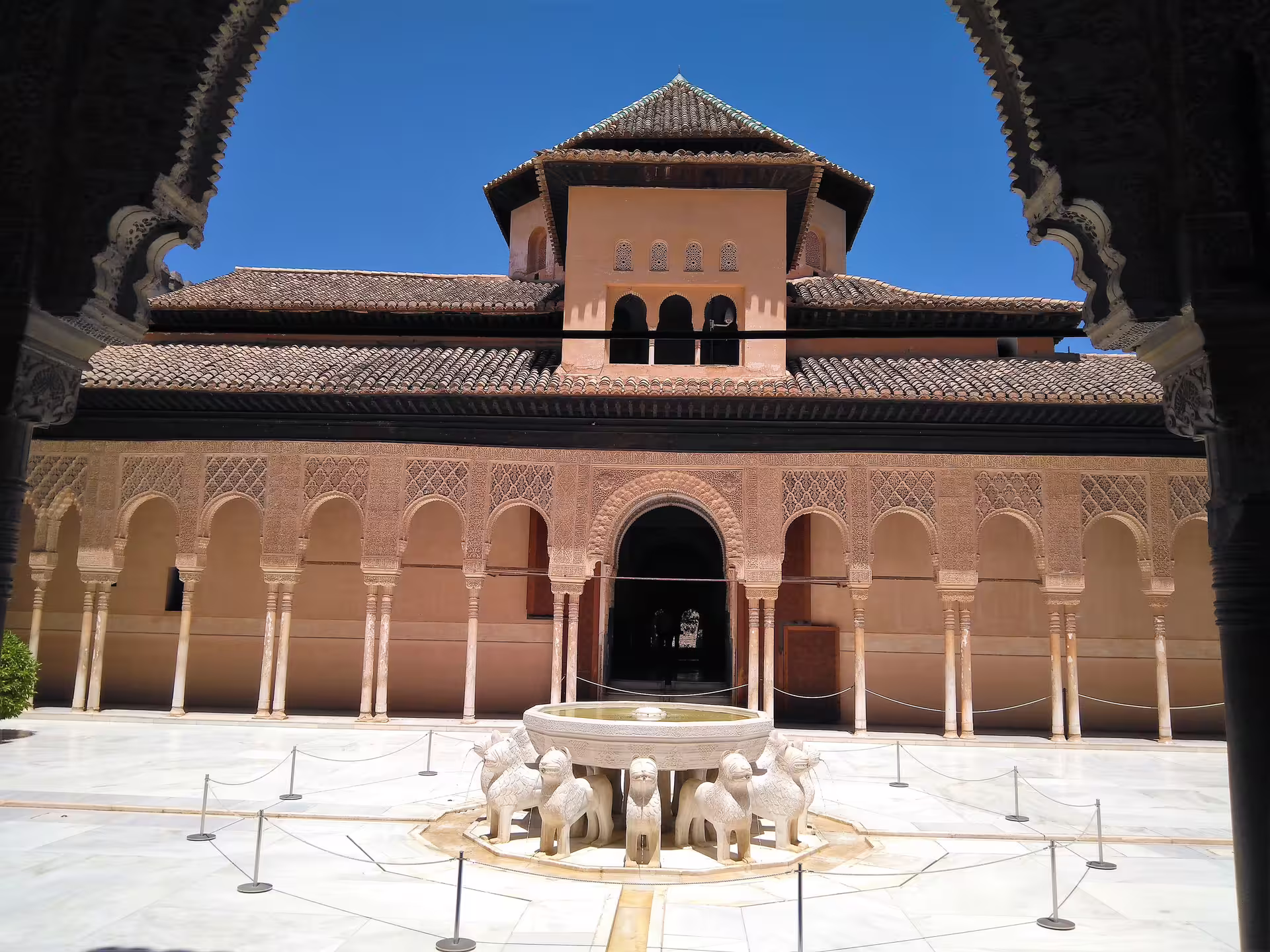 Wide view of Alhambra Court of the Lions, Granada, on private tour with hotel pick-up, fountain and arcades
