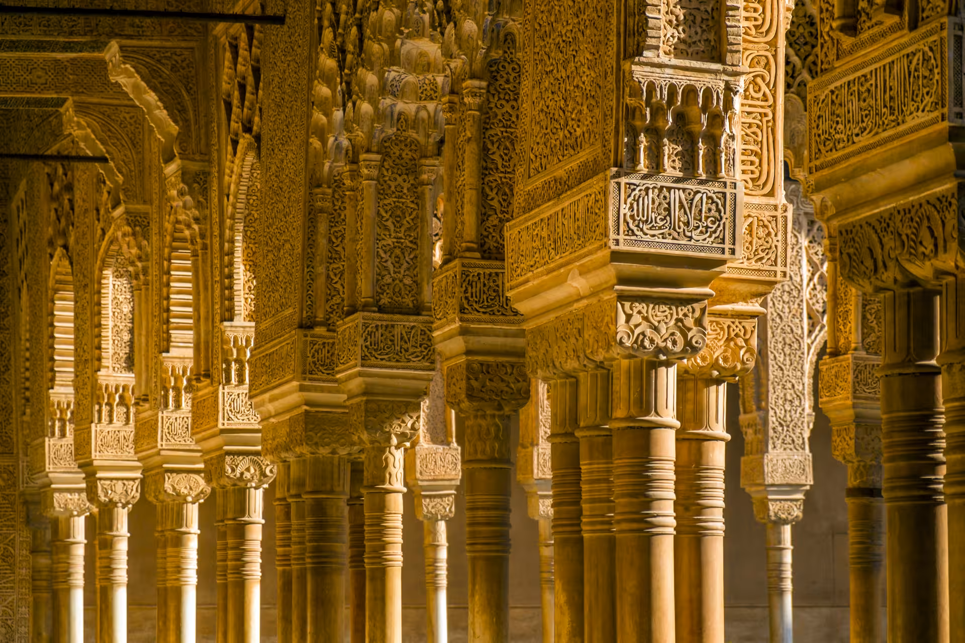 Ornate columns and arches of the Alhambra's Nasrid Palaces, highlighting detailed Moorish architecture in Granada.