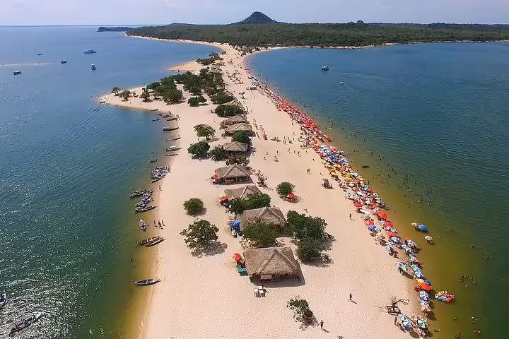 Aerial view of Ilha do Amor sandbar in Alter do Chao, Tapajós River beach huts and umbrellas