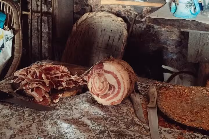 Rustic Italian charcuterie spread on a table, featuring cured meats, inviting a taste of local flavors on the trek.