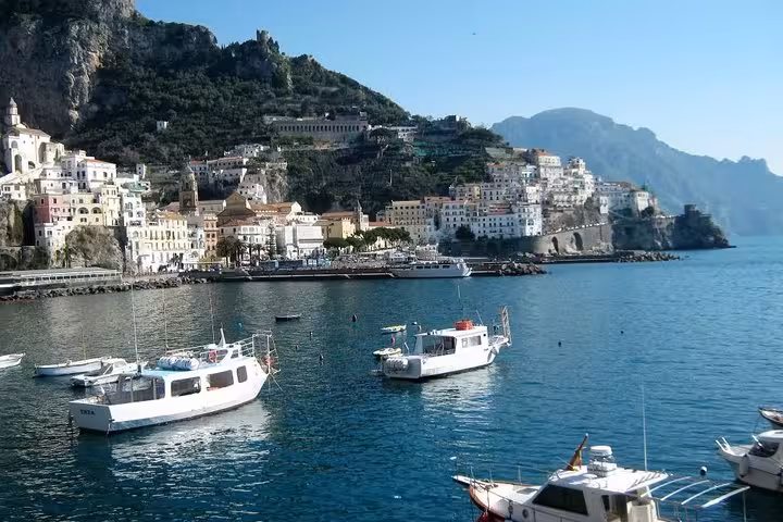 Scenic view of Amalfi coastline with boats anchored in the clear blue sea, perfect for a full-day tour to Positano.