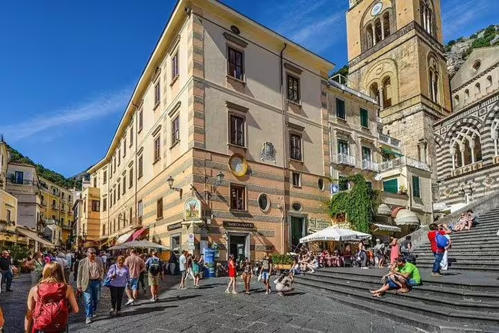 Tourists relaxing on steps in Amalfi town square beside the cathedral and cafes during a private top sights walking tour
