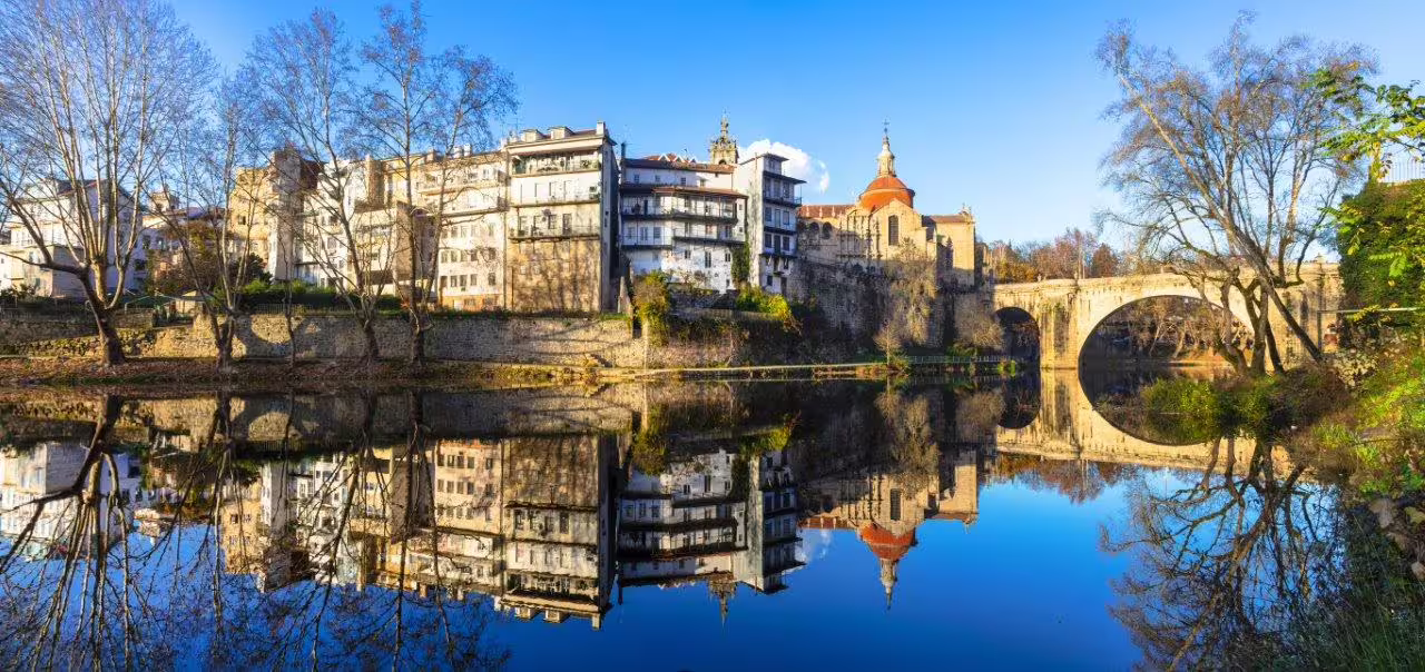 Scenic view of Amarante's historic architecture and Tâmega River reflection, part of Portugal's northern self-drive tour.