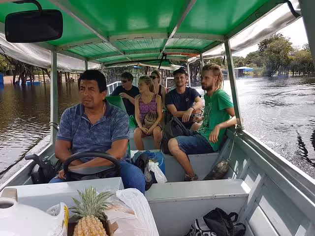 Travelers riding a covered boat through flooded Amazon rainforest, river transfer on a 3-day jungle adventure tour