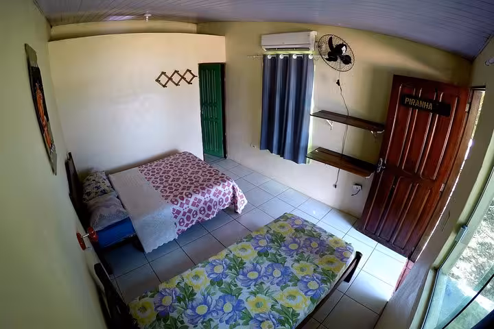 Simple Amazon jungle lodge bedroom with twin beds and AC, stay included in 3-day Amazon jungle adventure tour