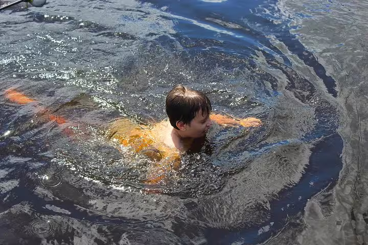 A person swimming in the clear waters of the Amazon, experiencing adventure at Amazon Mamori Lodge.