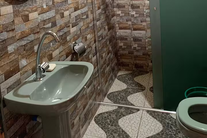 Modern bathroom with stone tiles at Amazon Mamori Lodge, combining comfort and rustic charm in the jungle.
