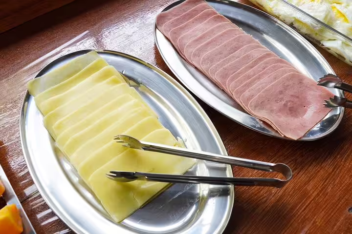 Plates of sliced cheese and ham served at Amazon Mamori Lodge, perfect for a hearty jungle adventure breakfast.