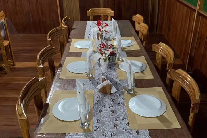 Elegant table setting with floral arrangements in the dining room of Amazon Mamori Lodge.