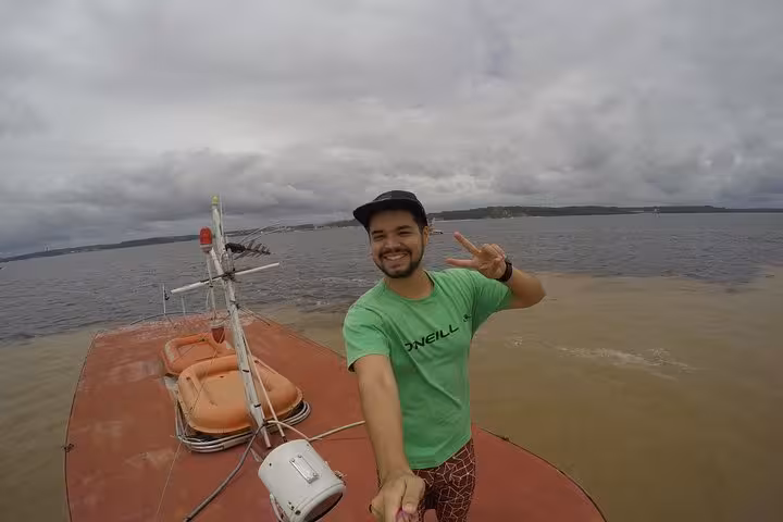 Traveler on Amazon River boat near Manaus at Meeting of the Waters, scenic rainforest cruise photo