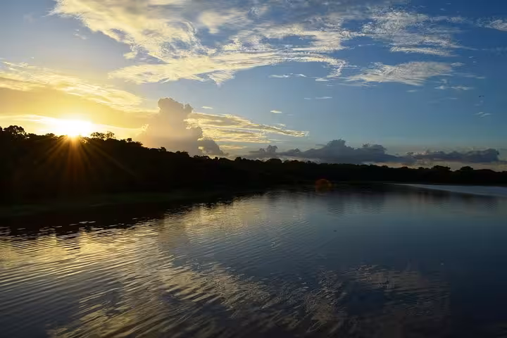 Sunset over the Amazon River with rainforest silhouette, scenic view on a Manaus riverboat adventure tour
