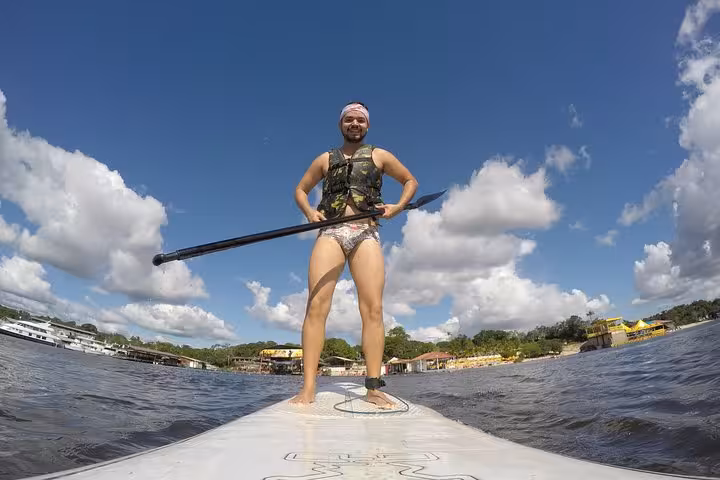 Paddler standing on a SUP board on the Amazon River, enjoying a scenic stand up paddling tour near Manaus