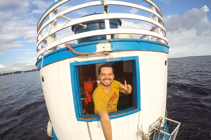 Smiling traveler on Amazon riverboat deck near Manaus, enjoying a guided Amazon River boat adventure cruise