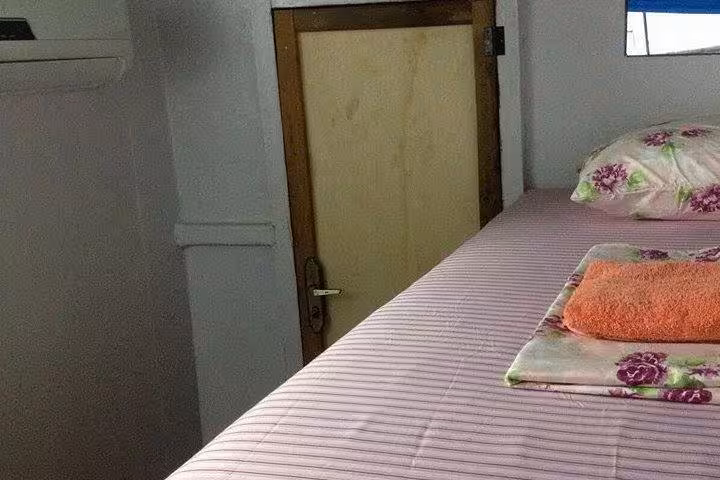 Simple cabin bed with fresh linens on an Amazon riverboat, Manaus overnight adventure cruise accommodation