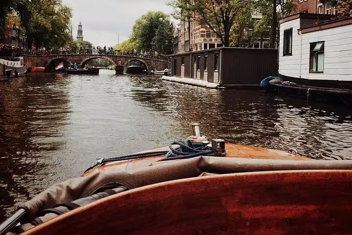 Amsterdam canal view from a boat near arched bridge, iconic scenery on a private walking tour of famous painters