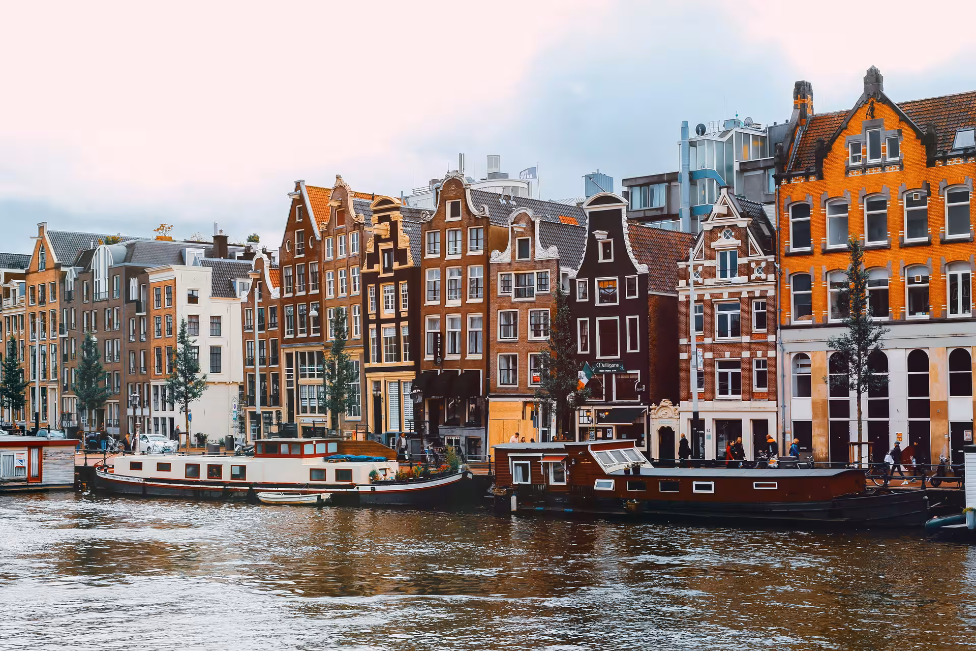 Canal houses and houseboats on Amsterdam waterways, highlight of a 3–5 hour private layover tour