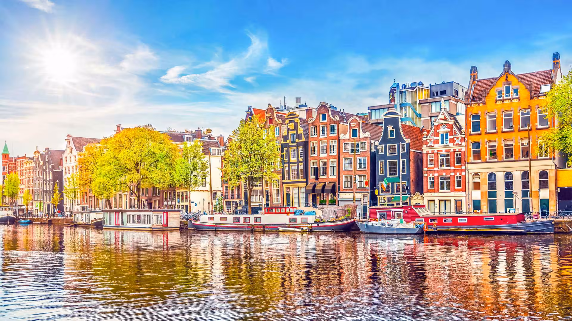 Amsterdam canal houses and houseboats by the water, scenic stop on private Rotterdam to Kinderdijk and Amsterdam tour