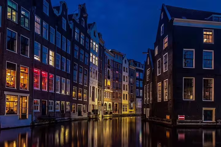 Night view of Amsterdam canal houses with reflections, private half-day sightseeing tour in the city
