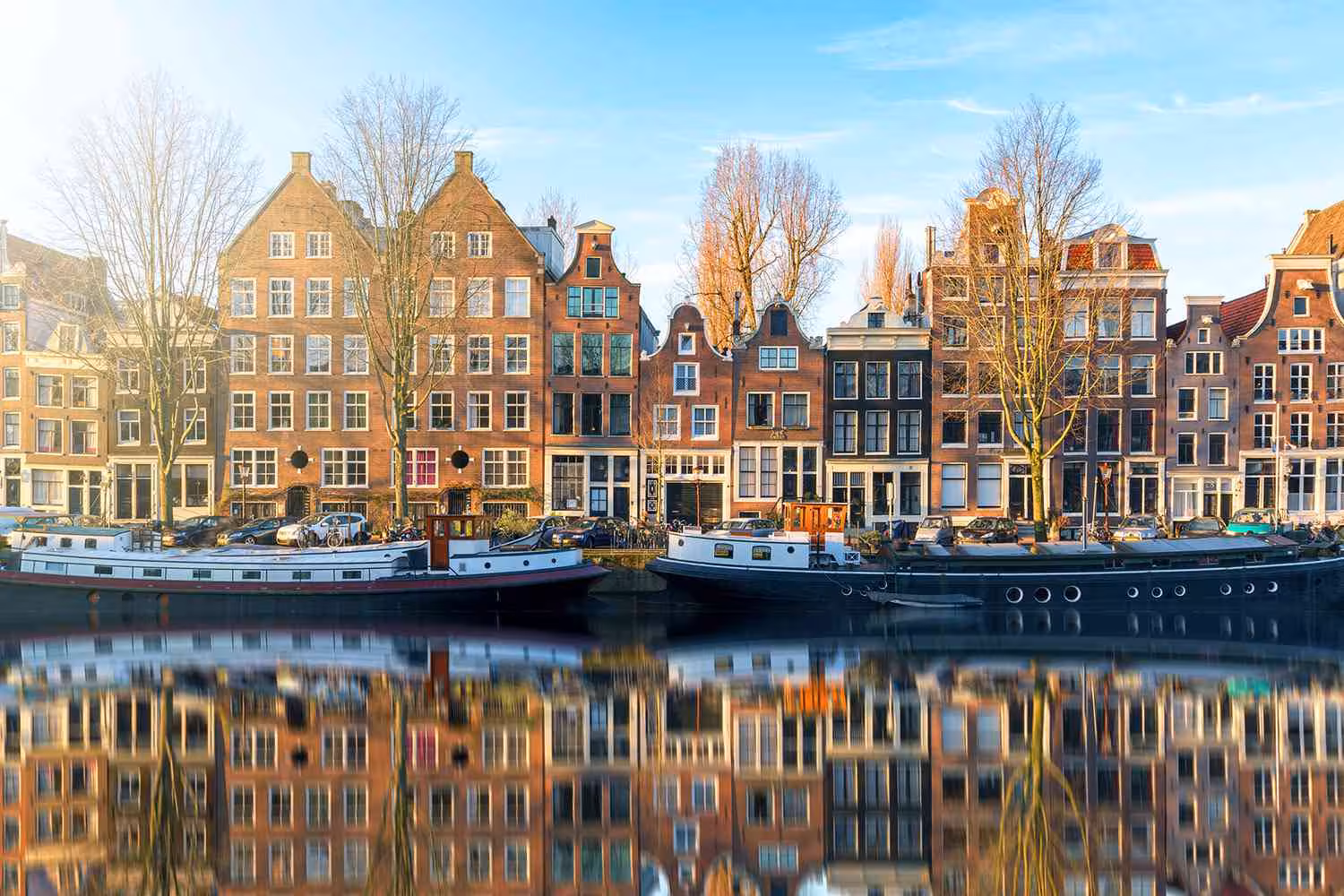 Amsterdam canal houses and boats at sunset, scenic stop on private tour from Rotterdam to Kinderdijk and Amsterdam