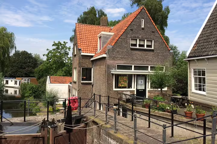Dutch canal house and lock on Amsterdam countryside bike tour, scenic stop on private guided ride