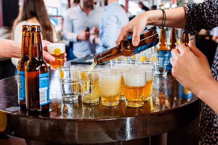 Guest sampling Dutch craft beer in a cozy Amsterdam bar on a guided beer tasting with cheese and sausage