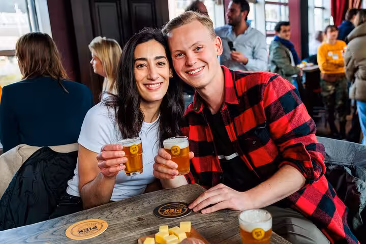 Couple cheers with local craft beer flights during guided Amsterdam beer tasting tour with cheese and sausage