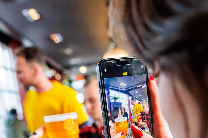 Guest photographing a craft beer flight during guided Amsterdam beer tasting with cheese and sausage pairing