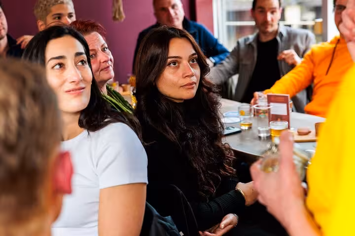Guests listen to the guide at an Amsterdam craft beer tasting tour with cheese and sausage pairings