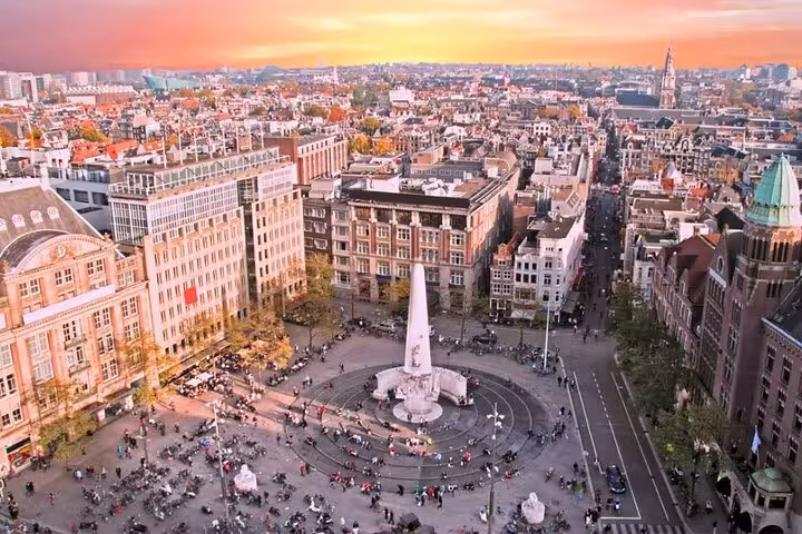 Aerial view of Amsterdam Dam Square at sunset, ideal start for private transfer to Schiphol Airport