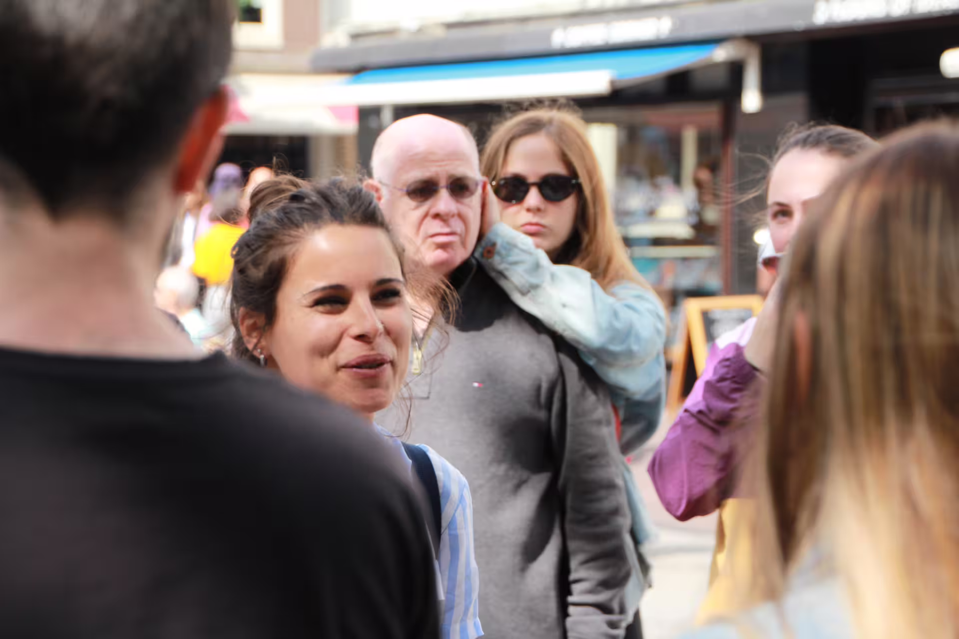 A group of tourists enjoys a guided walking tour in Amsterdam, highlighting cultural sites and local experiences.