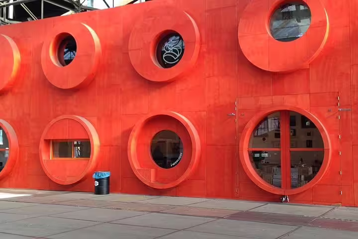 Bold red circular-window facade in Amsterdam Noord, a modern stop on a private guided bike tour